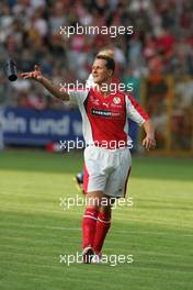 21.07.2004 Mannheim, Deutschland, "Spiel des Herzens", here: Michael Schumacher, GER, Ferrari throws a water bottle - Fair Play für Kinder in Not at Carl-Benz-Stadion Mannheim, the F1 Superstars (Michael Schumacher) plays against the RTL-Superstars, Charity, RTL Stiftung "Kinder in Not", UNESCO, before the Formula 1 World Championship, Rd 12, Grosser Mobil 1 Preis von Deutschland, GER, Hockenheimring Baden-Württemberg