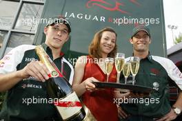 24.04.2004 Imola, San Marino, F1, Saturday, April, Christian Klien, AUT, Jaguar with Mumm Champagne girl and Mark Webber, AUS, Jaguar - Formula 1 World Championship, Rd 4, San Marino Grand Prix, RSM - Mumm Copyright Free