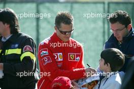 25.04.2004 Imola, San Marino, F1, Sunday, April, Michael Schumacher, GER, Ferrari arrive at the track side with a scooter and gives autographs to fans - Podium, Formula 1 World Championship, Rd 4, San Marino Grand Prix, RSM