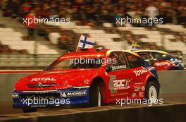 04.12.2004 Paris, France,  Saturday, Marcus Gronholm (FIN), WRC driver, Team Peugeot Sport (front), racing against Mattias Ekstrom (SWE), DTM driver, Team Abt-Audi (rear) - 17th Race of Champions 2004, Stade de France, Paris, France