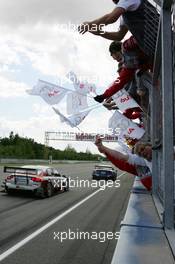 05.06.2005 Brno, Czech Republic,  Mattias Ekström (SWE), Audi Sport Team Abt Sportsline, Audi A4 DTM (front) and Tom Kristensen (DNK), Audi Sport Team Abt, Audi A4 DTM (rear), passing the Abt Audi team after finishing 1st and 2nd in the race - DTM 2005 at Automotodrom Brno, Czech Republic (Deutsche Tourenwagen Masters)