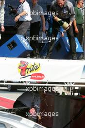 01.05.2005 Klettwitz, Germany,  Hans-Jürgen Mattheis (GER), Team Manager HWA (on the podium), tries to spray champaign over Norbert Haug (GER), Sporting Director Mercedes-Benz, which is hiding under the podum - DTM 2005 at Eurospeedway Lausitzring (Deutsche Tourenwagen Masters)