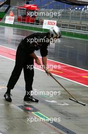 16.09.2005 Klettwitz, Germany,  A mechanic swipping the pitlane in front of the pitbox to remove the standing water - DTM 2005 at Lausitzring (Deutsche Tourenwagen Masters)