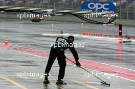 16.09.2005 Klettwitz, Germany,  Mechanic swipping the pitlane in front of the pitbox to remove standing water - DTM 2005 at Lausitzring (Deutsche Tourenwagen Masters)