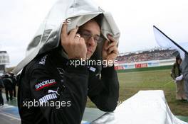 23.10.2005 Hockenheim, Germany,  Mechanic hidding under a cover for the rain - DTM 2005 at Hockenheimring (Deutsche Tourenwagen Masters)