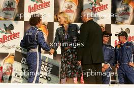 16.07.2005 Nürnberg, Germany,  Podium, Alain Prost (FRA) (1st), hands over the cheque of 500.000 euro to Veronica Ferres (GER), actice and ambassador of the Power Child charity - DTM 2005 Race of the Legends at Norisring (Deutsche Tourenwagen Masters)