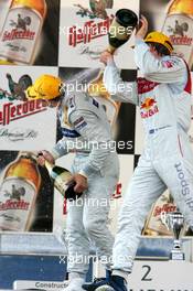 26.06.2005 Oschersleben, Germany,  Podium, Gary Paffett (GBR), DaimlerChrysler Bank AMG-Mercedes, Portrait (1st, left), gets a champaign shower from Mattias Ekström (SWE), Audi Sport Team Abt Sportsline, Portrait (2nd, right) - DTM 2005 at Motopark Oschersleben (Deutsche Tourenwagen Masters)