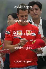 14.10.2005 Shanghai, China,  Michael Schumacher, GER, Ferrari signs an autograph for a Chinese fan - October, Formula 1 World Championship, Rd 19, Chinese Grand Prix, Friday