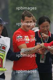 14.10.2005 Shanghai, China,  Michael Schumacher, GER, Ferrari sings an autograph for a Chinese fan - October, Formula 1 World Championship, Rd 19, Chinese Grand Prix, Friday