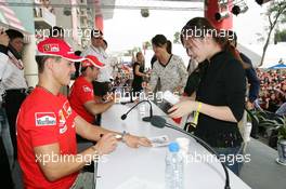 15.10.2005 Shanghai, China,  Michael Schumacher, GER, Ferrari signs an autograph for a Chinese fan - October, Formula 1 World Championship, Rd 19, Chinese Grand Prix, Saturday