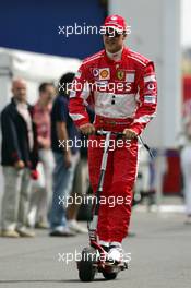 01.07.2005 Magny-Cours, France,  Michael Schumacher (GER), Scuderia Ferrari Marlboro, Portrait, driving an electric scooter through the paddock - July, Formula 1 World Championship, Rd 10, French Grand Prix, Magny Cours, France, Practice