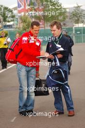 08.07.2005 Silverstone, England, Michael Schumacher (GER), Scuderia Ferrari Marlboro, Portrait, signing a book for a ITV journalist - July, Formula 1 World Championship, Rd 11, British Grand Prix, Silverstone, England