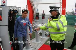 07.07.2005 Silverstone, England A poiliceman asks Giancarlo Fisichella (ITA), Mild Seven Renault F1 Team, Portrait, to have his bag checked at the entry of the Formula One paddock - July, Formula 1 World Championship, Rd 11, British Grand Prix, Silverstone, England