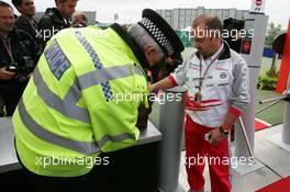 07.07.2005 Silverstone, England Mike Gascoyne (GBR), Technical Director Chassis Toyota Racing, having his bags checked at the entry of the Formula One paddock - July, Formula 1 World Championship, Rd 11, British Grand Prix, Silverstone, England