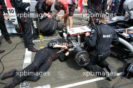 31.07.2005 Hungaroring, Hungary, McLaren mechanics repair the front end of Montoya's car as he run over a Honda power generator when driving on to the grid which damaged the front of the car heavily - July, Formula 1 World Championship, Rd 13, Hungarian Grand Prix, Budapest, Hungary, HUN, Grid