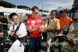 06.10.2005 Suzuka, Japan, Michael Schumacher, GER, Ferrari signs an autograph for a Japanese fan  - October, Formula 1 World Championship, Rd 18, Japanese Grand Prix