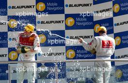 30.04.2006 Klettwitz, Germany,  Champagne spraying on the DTM podium:(left) Tom Kristensen (DNK), Audi Sport Team Abt Sportsline, Audi A4 DTM; (right) Bernd Schneider (GER), AMG-Mercedes, AMG-Mercedes C-Klasse - DTM 2006 at Eurospeedway Lausitzring (Deutsche Tourenwagen Masters)