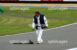 13.10.2006 Le Mans, France,  Trackmarshal picking up debris left behind by the DTM cars on the track. - DTM 2006 at Le Mans Bugatti Circuit, France (Deutsche Tourenwagen Masters)