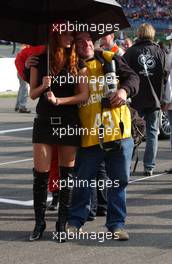 29.10.2006 Hockenheim, Germany,  A bit not so professional photographer poses for his personal photo-album with a high heeled gridgirl..... - DTM 2006 at Hockenheimring (Deutsche Tourenwagen Masters)