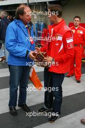 20.10.2006 Sao Paulo, Brazil,  Michael Schumacher (GER), Scuderia Ferrari, receives a gift from a journalist - Formula 1 World Championship, Rd 18, Brazilian Grand Prix, Friday