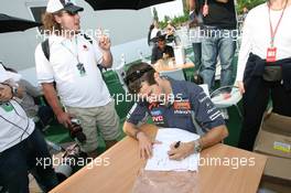 23.06.2006 Montreal, Canada,  Tiago Monteiro (POR), Midland MF1 Racing, signs Canada Edition T-shirts for fans and friends - Formula 1 World Championship, Rd 9, Canadian Grand Prix, Friday
