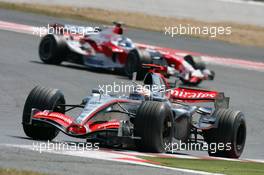 16.07.2006 Magny Cours, France,  Kimi Raikkonen (FIN), Räikkönen, McLaren Mercedes, MP4-21 and Jarno Trulli (ITA), Toyota Racing, TF106 - Formula 1 World Championship, Rd 11, French Grand Prix, Sunday Race