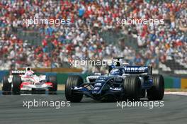 16.07.2006 Magny Cours, France,  Nico Rosberg (GER), WilliamsF1 Team, FW28 Cosworth leads Franck Montagny (FRA), Super Aguri F1, Super Aguri F1, SA05 - Formula 1 World Championship, Rd 11, French Grand Prix, Sunday Race