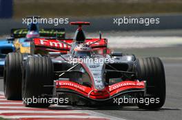 16.07.2006 Magny Cours, France,  Kimi Raikkonen (FIN), Räikkönen, McLaren Mercedes, MP4-21 leads Giancarlo Fisichella (ITA), Renault F1 Team, R26 - Formula 1 World Championship, Rd 11, French Grand Prix, Sunday Race