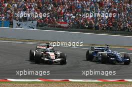 16.07.2006 Magny Cours, France,  Jenson Button (GBR), Honda Racing F1 Team, RA106, passes Nico Rosberg (GER), WilliamsF1 Team, FW28 Cosworth - Formula 1 World Championship, Rd 11, French Grand Prix, Sunday Race