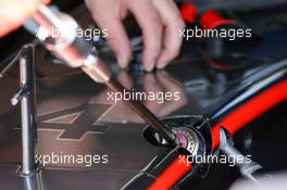 15.07.2006 Magny Cours, France,  A mechanic replacing a long round part, probably related to the suspension of the McLaren MP4-21 - Formula 1 World Championship, Rd 11, French Grand Prix, Saturday Practice