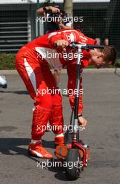 15.07.2006 Magny Cours, France,  Michael Schumacher (GER), Scuderia Ferrari 248 F1, on a small step, with some empty cans hanging behind his step which Bridgestone engineers put behind it - Formula 1 World Championship, Rd 11, French Grand Prix, Saturday