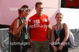 15.07.2006 Magny Cours, France,  Michael Schumacher (GER), Scuderia Ferrari, posing for a photo with some girls in the paddock - Formula 1 World Championship, Rd 11, French Grand Prix, Saturday