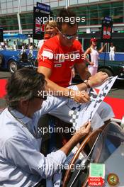 16.07.2006 Magny Cours, France,  Michael Schumacher (GER), Scuderia Ferrari, Portrait, signing autographs for the driver of his car during the driver parade - Formula 1 World Championship, Rd 11, French Grand Prix, Sunday