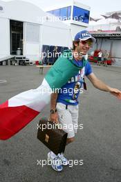 13.07.2006 Magny Cours, France,  Jarno Trulli (ITA), Toyota Racing, Portrait, coming into the paddock with an Italian flag around him and a football World Champion T-shirt - Formula 1 World Championship, Rd 11, French Grand Prix, Thursday