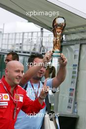 13.07.2006 Magny Cours, France,  Italian Ferrari team members enter the paddock holding up a dummy football World Cup trophy - Formula 1 World Championship, Rd 11, French Grand Prix, Thursday