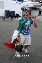 13.07.2006 Magny Cours, France,  Jarno Trulli (ITA), Toyota Racing, Portrait, coming into the paddock with an Italian flag around him and a football World Champion T-shirt - Formula 1 World Championship, Rd 11, French Grand Prix, Thursday