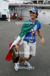 13.07.2006 Magny Cours, France,  Jarno Trulli (ITA), Toyota Racing, Portrait, coming into the paddock with an Italian flag around him and a football World Champion T-shirt - Formula 1 World Championship, Rd 11, French Grand Prix, Thursday