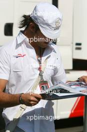 09.06.2006 Silverstone, England,  Vitantonio Liuzzi (ITA), Scuderia Toro Rosso, reads the Red Bulletin - Formula 1 World Championship, Rd 8, British Grand Prix, Friday