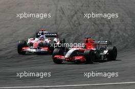 30.07.2006 Hockenheim, Germany,  Christijan Albers (NED), Midland F1 Racing M16, overtakes Takuma Sato (JPN), Super Aguri F1 SA06, on the outside at the hairpin - Formula 1 World Championship, Rd 12, German Grand Prix, Sunday Race