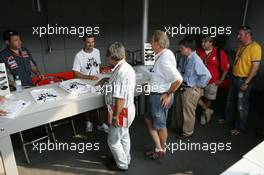 07.09.2006 Monza, Italy,  Tiago Monteiro (POR), Midland MF1 Racing signs his Monza edition t-shirt, Ron Fine (CDN), Head of Communications, Midland MF1 Racing (Far Left) - Formula 1 World Championship, Rd 15, Italian Grand Prix, Thursday