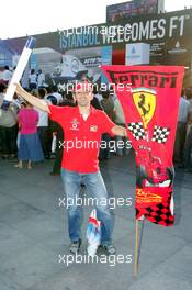 23.08.2006 Istanbul, Turkey,  A Ferrari fan stands in front of an advertising banner in downtown Istanbul - Formula 1 World Championship, Rd 14, Turkish Grand Prix, Wednesday