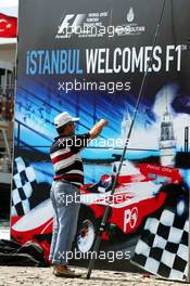 23.08.2006 Istanbul, Turkey,  A fisher stands in front of an advertising banner in downtown Istanbul - Formula 1 World Championship, Rd 14, Turkish Grand Prix, Wednesday