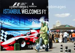 23.08.2006 Istanbul, Turkey,  A woman wearing a scarf walks in front of an advertising banner - Formula 1 World Championship, Rd 14, Turkish Grand Prix, Wednesday