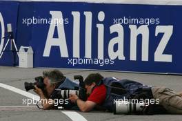 30.06.2006 Indianapolis, USA,  Photographers taking photos on the floor - Formula 1 World Championship, Rd 10, United States Grand Prix, Friday Practice