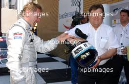 20.05.2007 Klettwitz, Germany,  (right) Norbert Haug (GER), Sporting Director Mercedes-Benz relieves Mika Häkkinen (FIN), Team HWA AMG Mercedes, AMG Mercedes C-Klasse from his helmet. - DTM 2007 at Eurospeedway Lausitz (Lausitzring)