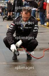 23.06.2007 Nürnberg, Germany,  HWA mechanic trying frantically to blow some of the concrete in front of the pitbox dry before the qualifying. - DTM 2007 at Norisring