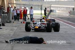 23.02.2007 Sakhir, Bahrain,  Mark Webber (AUS), Red Bull Racing and a photographer lying down in the pitlane - Formula 1 Testing