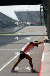 04.10.2007 Shanghai, China,  Nelson Piquet Jr (BRA), Test Driver, Renault F1 Team, stretches against the wall on the pit straight - Formula 1 World Championship, Rd 16, Chinese Grand Prix, Thursday