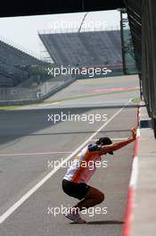 04.10.2007 Shanghai, China,  Nelson Piquet Jr (BRA), Test Driver, Renault F1 Team, stretches against the wall on the pit straight - Formula 1 World Championship, Rd 16, Chinese Grand Prix, Thursday