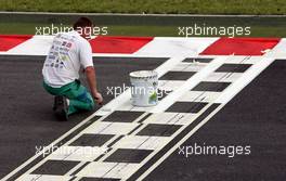 29.06.2007 Magny-Cours, France,  A man painting the start / finish line - Formula 1 World Championship, Rd 8, French Grand Prix, Friday